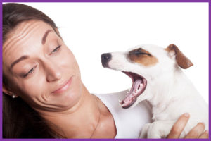 Woman holding dog with bad breath